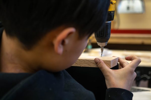 kid-using-drill-in-woodworking-shop-pet-photography